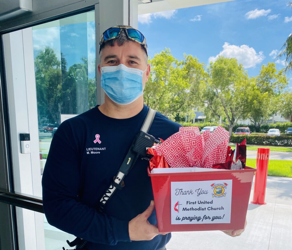 A fire fighter poses with his gift from First UMC of Naples