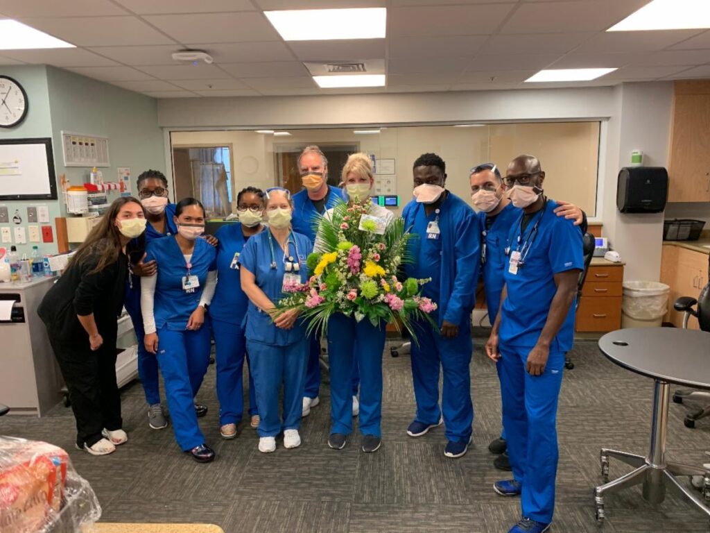 Hospital employees posing with their bouquet from First UMC