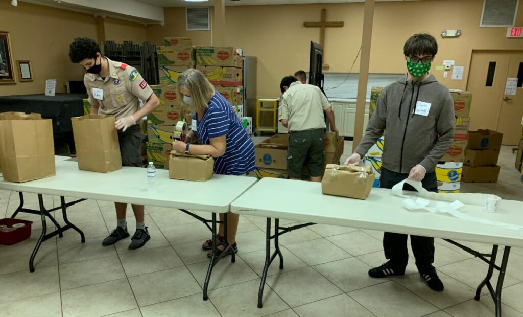 Church goers and boy scouts package goods from a food drive