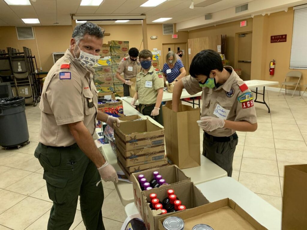 Boy scouts helping package food for a food drive